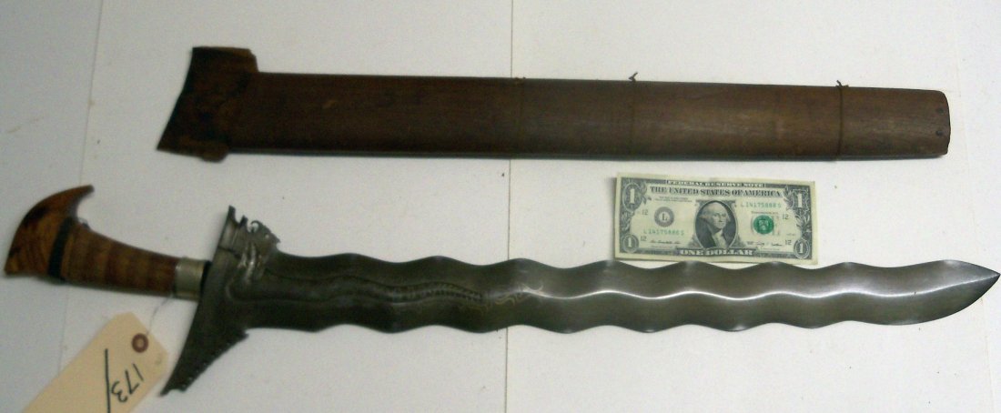 Very Fine 19th Century Datu's Moro Kris Sword: 23½ inch blade. The blade is in excelent condition,the handle has very old damage and repair. Plain wood scabbard with loss. From The William Herbert McGinty Collection. Collected between the late 18