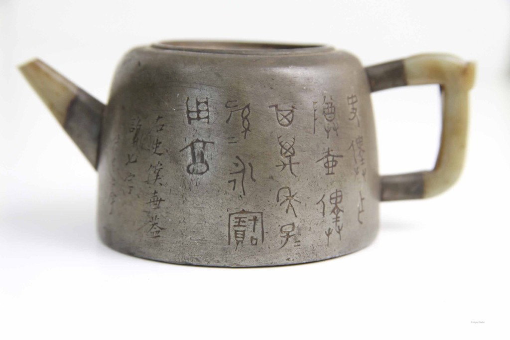 Chinese Pewter Yin Xin Jade Teapot: Chinese pewter Yin Xin jade teapot, round incised decoration, poem on the side, no lid Condition: Available Upon Request Dimensions: 6 1/2"L x 3"H