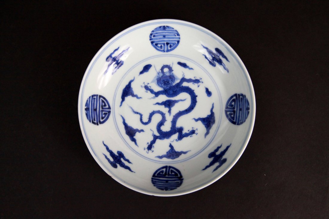 Chinese Blue and White Dish w/ Dragon Design: Chinese blue and white dish interior with dragon in the center surrounded by clouds in "Shuo" design, exterior decorated with clouds in "shou" design. Dimension: 6 1/2" Diam.