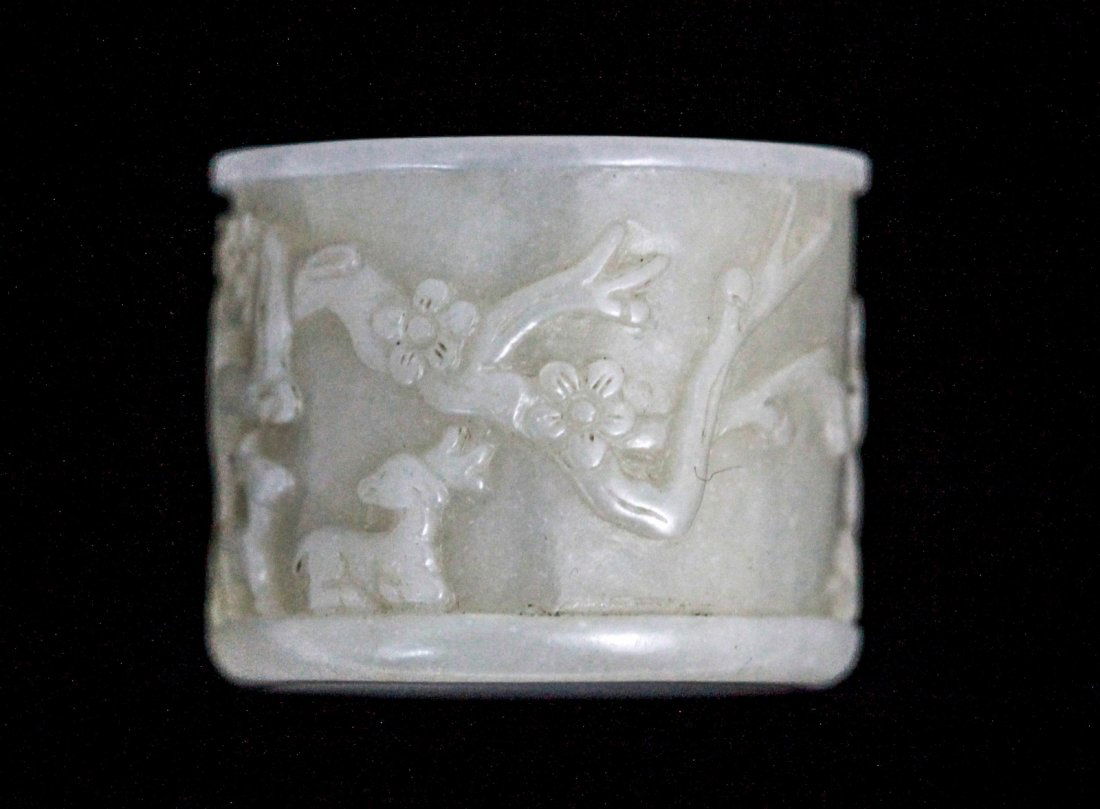 Chinese Jade Thumb Ring: Chinese jade thumb ring carved in relief with pine tree, bamboo and winter blossom (three friends) Dimension: 1 1/4" Diam