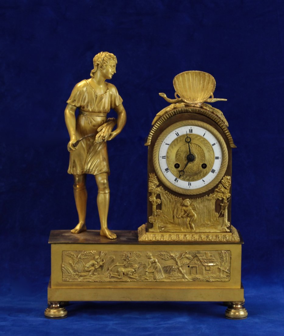 Late 18th Century Dore Bronze Clock: Dore Bronze Clock with Boy Farmer Holding Sheaf of Grains and Sickle with Snake under Basket and Two Farmers Scene Plaques Dimension: 11"L x 4 1/4"W x 14 1/2"H