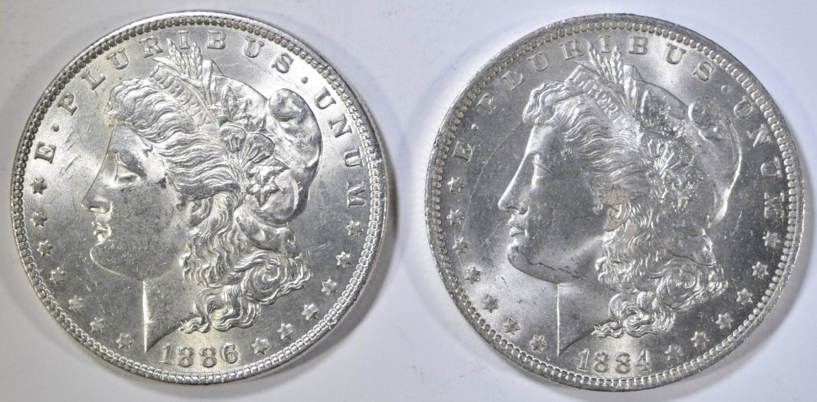 1884-O CH BU & 1886 BU MORGAN DOLLARS: CHECK OUT OUR UPCOMING AUCTIONS. ESTIMATE $90 - $110.