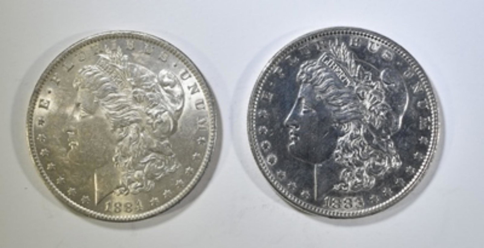 1883 & 1884-O BU MORGAN DOLLARS: WEEKLY COIN & CURRENCY AUCTIONS. ESTIMATE $110 - $130.