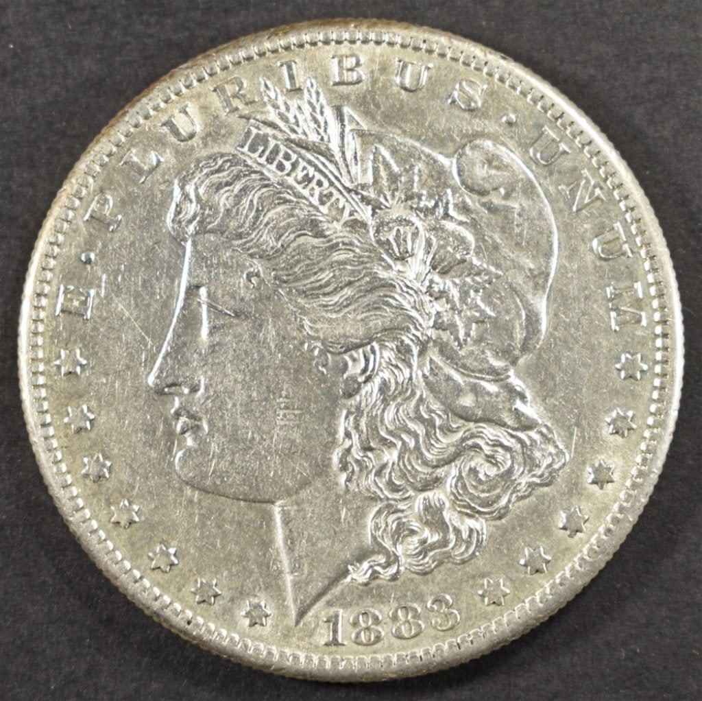 1883-S MORGAN DOLLAR AU: CHECK OUT OUR UPCOMING AUCTIONS ESTIMATE $200 - $250.