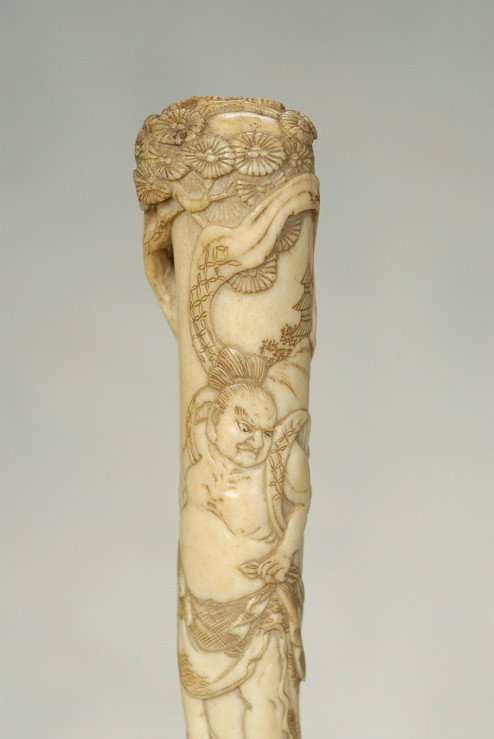 A Japanese staghorn cane of a Buddhist Nio: A very nice Japanese staghorn cane of a Buddhist Nio. The long, polished staghorn handle is 6" high and 1 1/8" at its widest. It depicts a relief-carved Buddhist Temple protector (Nio) with a feathere