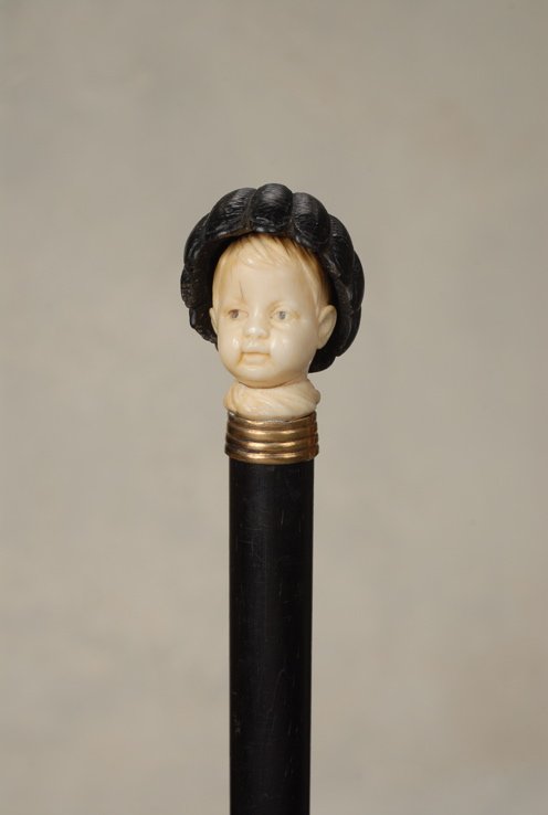 A very nice ivory child with an ebony basket hat: A very nice ivory child with an ebony basket hat. The ebony and elephant ivory handle is 1 1/2" high and 1 1/4" at its widest. It depicts in fine detail, a cherubic young boy whimsically wearing a wov