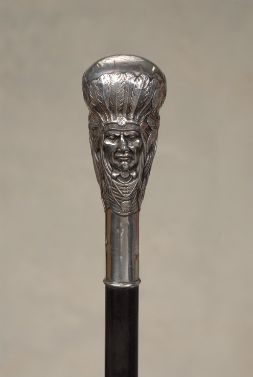 A silver Unger Brothers cane of American Indians: A splendid silver Unger Brothers cane of American Indians. The silver handle is 4" high and 1 1/4" in diameter. The top has large fancy initials for the original owner and the sides feature a matching