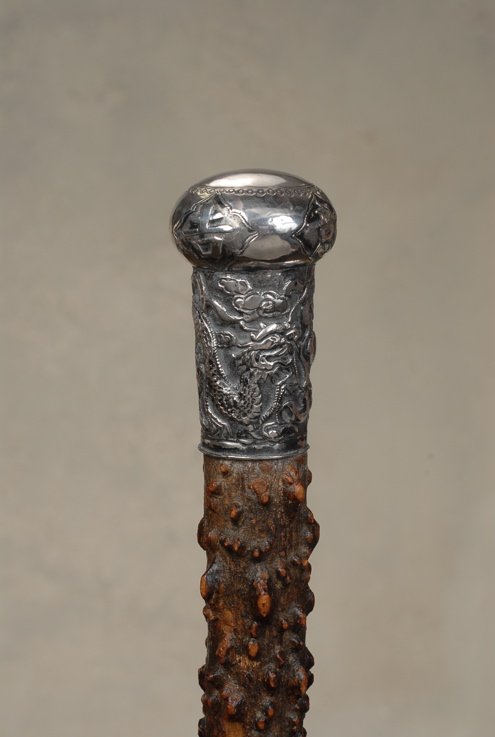 A Chinese silver cane with a dragon: A very good Chinese silver cane with a dragon and Chinese writing. The very large silver knob is 3" high and 1 3/4" in diameter. It has a smooth, round cartouche on the top with four panels of Chinese