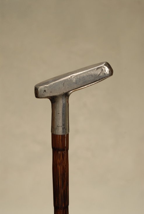 A very nice silver Sunday Stick putter cane: A very nice silver Sunday Stick putter cane. The silver handle is 2" high, 2 3/4" long, and 7/8" wide. It depicts a golf putter with a flat side opposite a slightly rounded one, in true putter configu