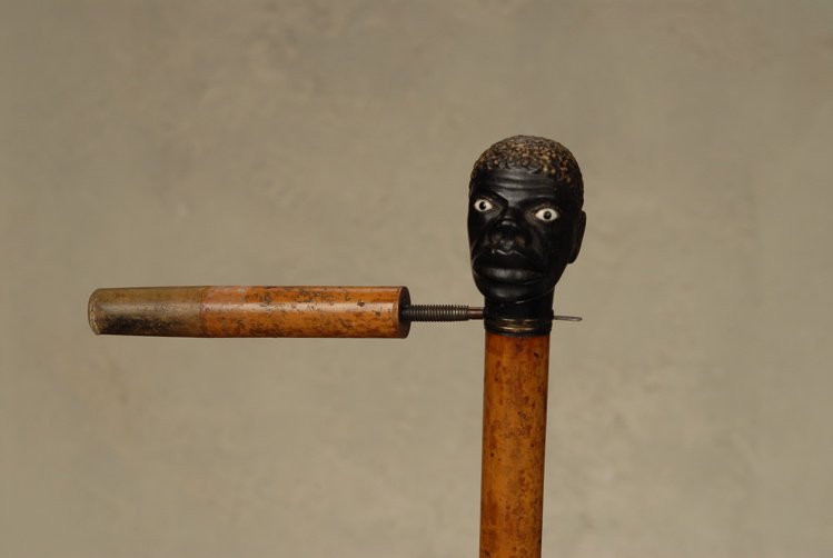 A great black man beheading cane: A great black man beheading cane. The ebony handle is 2 1/3” high and 1 7/8” at its widest. It depicts a wonderfully detailed head of a black man with white sulfide eyes and a startled expression.