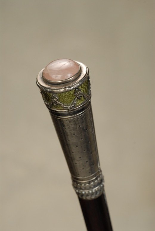 An Austrian silver and enamel cane with rose quartz: A marvelous Austrian silver and enamel cane with rose quartz inlay. The cylindrical silver handle is 3 1/8” high and 7/8” across the top. There is a 2/3” rose quartz rounded disc inlaid in a bez
