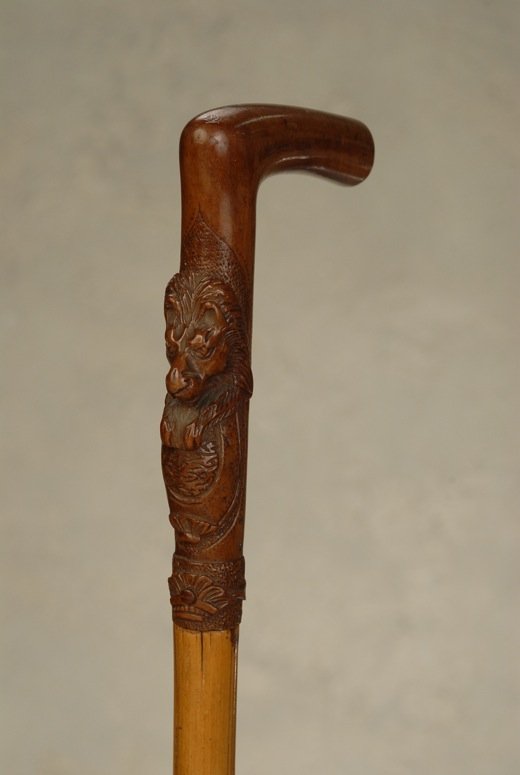 A sword cane curio with a carved wood lion: A very good sword cane curio with a carved wood lion. The dark fruitwood “L” handle is 5 1/3” high and 3 1/3” to the side. On the stem portion, the head of a male lion with its paws resting on