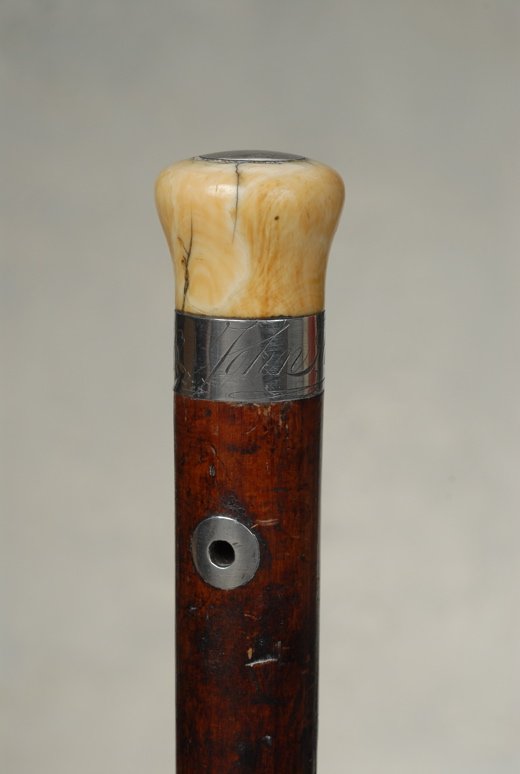 An early cane with "John Hancock, 1776" on it: A very nice early cane with the name "John Hancock, 1776" on it. The whale ivory knob handle is 1 1/8" high and 1 1/3" across the top. Inlaid on top is a 7/8" smooth, coin silver disc as a decorative