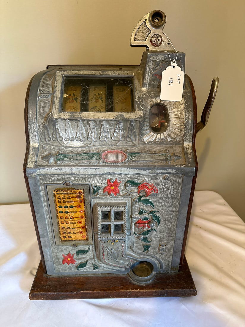 Antique 5 Cent Slot Machine: A classic vintage slot machine featuring ornate floral designs and a robust lever mechanism, perfect for antique collectors. Its exterior shows charming wear that adds to its nostalgic appeal. Ideal a