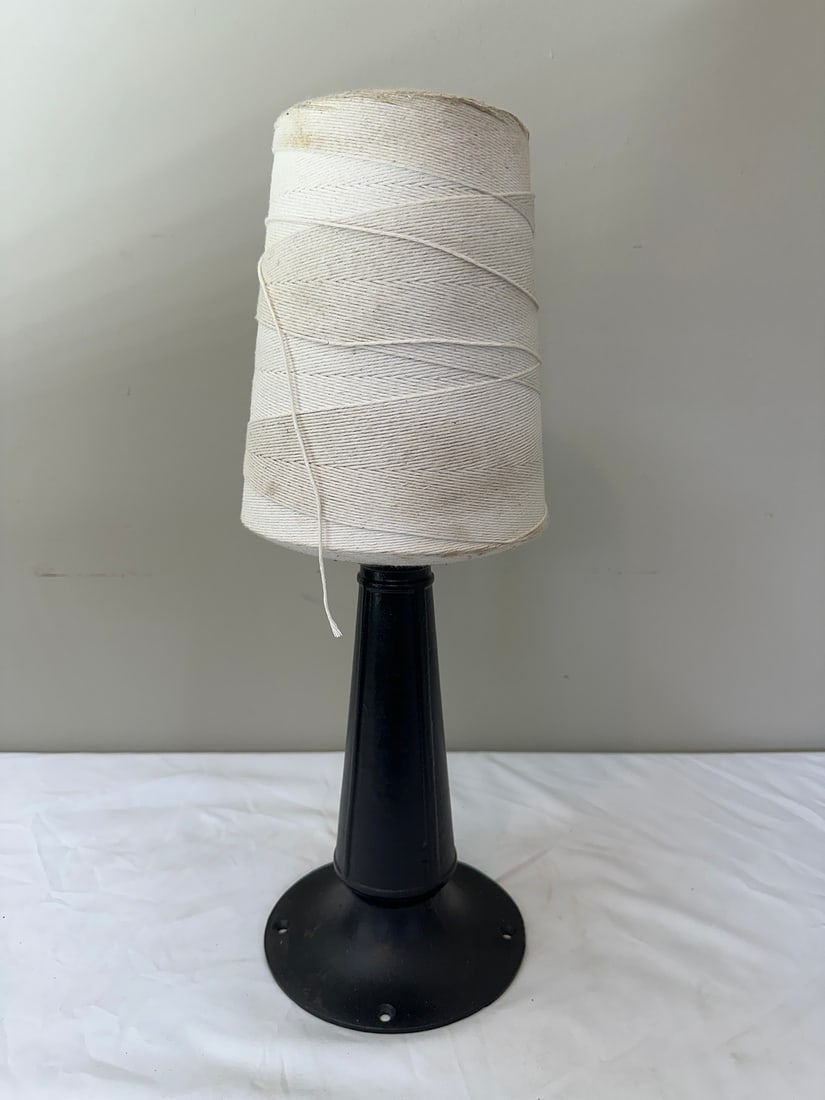 Large Cone of White Twine on Stand: This large cone of white twine is perfect for crafting, packaging, or gardening. Mounted on a sturdy black metal stand, it provides easy access and organization. Ideal for DIY enthusiasts and professi