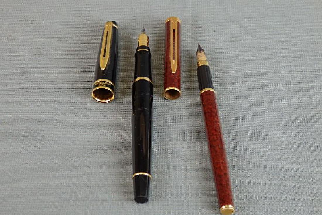 Waterman Fountain Pen Lot 1 with a 18k Point: The reddish one has some scratches to it. The point is marked Waterman Ideal Paris 18k 750. The other has some wear on it from use and the point is marked Waterman France m.