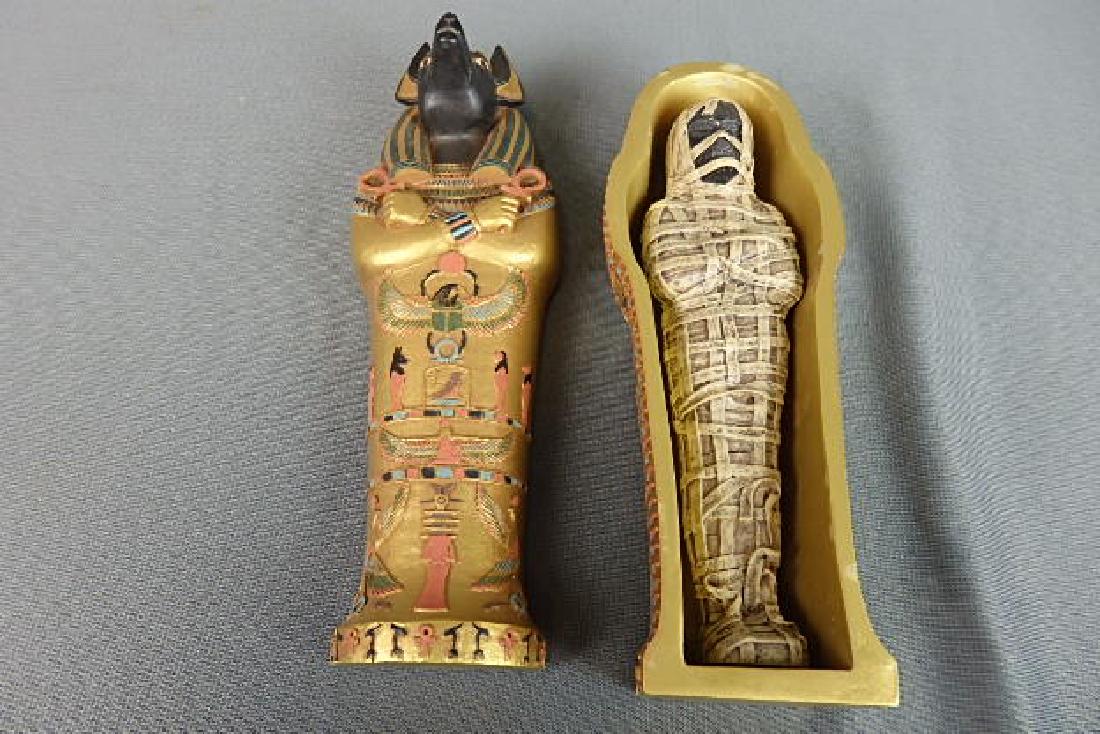 Egyptain Coffin with Mummy: Marked on the inside of the bottom part of the coffin 2003 AT. Made of a heavy resin material. 3 pieces the top and bottom part of the coffin and a mummy. The length is 7.5 inches, height is 3.5 and 2
