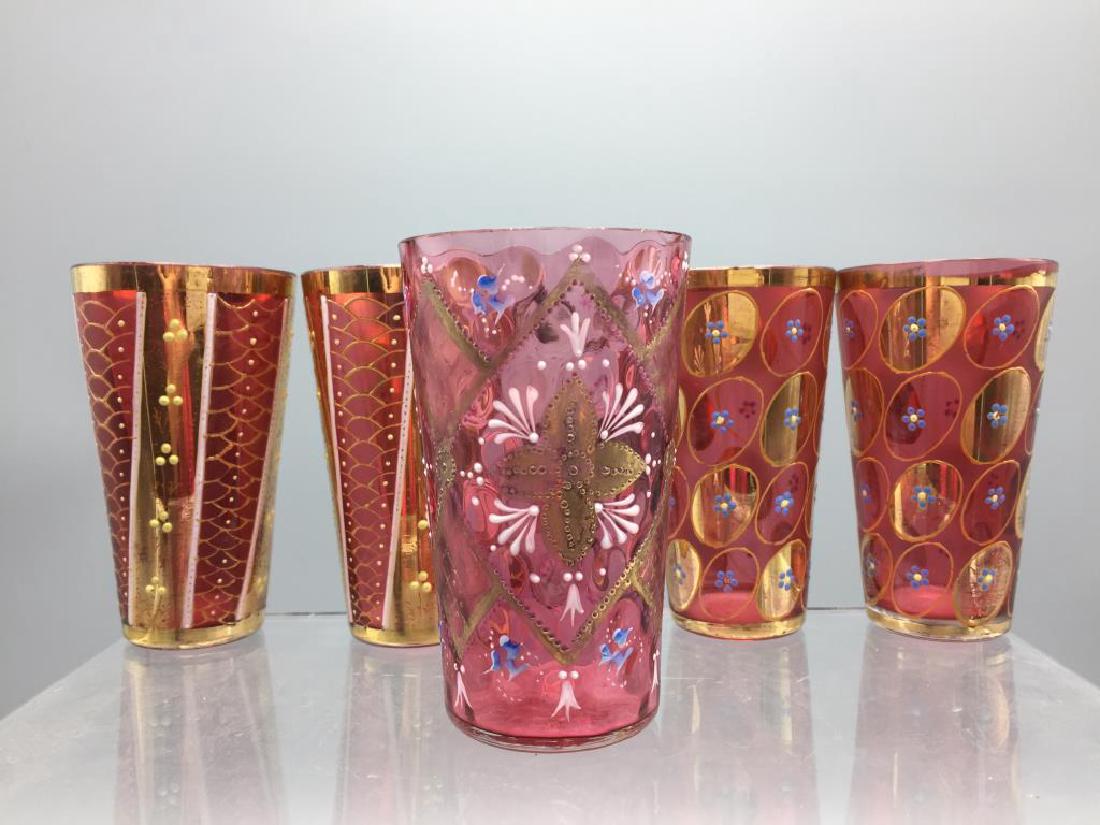 5 Cranberry Moser glass tumblers: There are two sets of two and one odd pattern, roughly 4 inches in height the two sets of two are OK and color loss at rims to gilding, the odd single has a chips.
