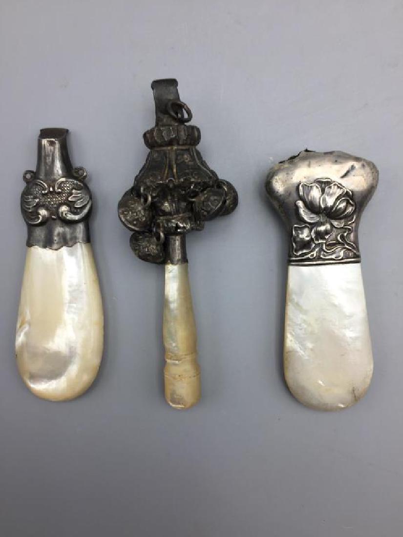 Babies Victorian rattles and whistle: 3 items, mother of pearl and sterling handles, some dents , the whistle is not marked, different designs. Length is just over 3 inches
