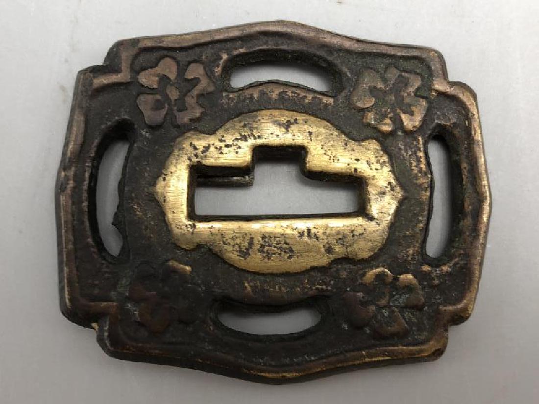 Japanese Tsuba: Two tone bronze piece used as hand guard mounted on a sword. Details of 4 leaf clovers on both sides. Bottom side has some wear around the Nakago-Ana where weapon was inserted. 2.5 inches long x 2 inc