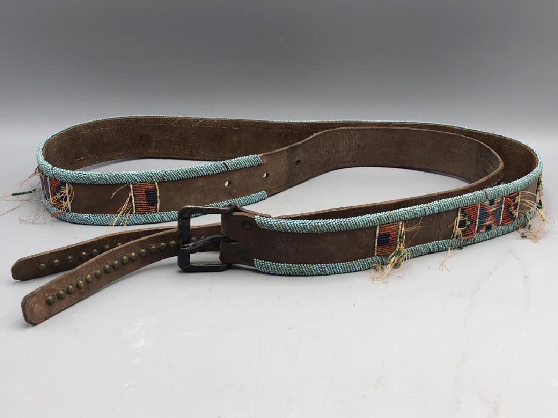 Early Native Beadwork Belt: Turquoise beads along the edges of the belt with colorful, tribal pattern decorating the middle in red, yellow, white, green and purple. Belt is studded with buckle. The thread has frayed in various s
