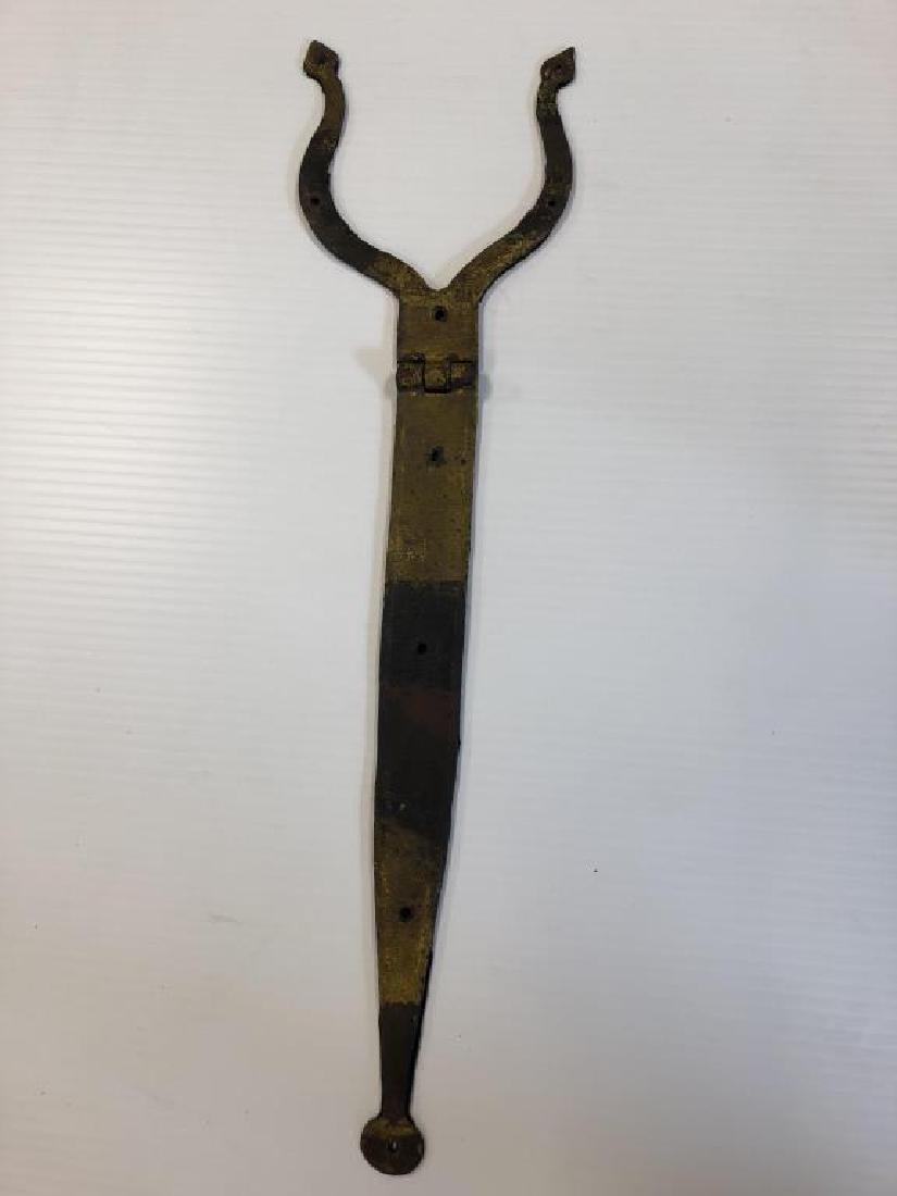 Flat Cast Iron Bracket: Decorative piece is felted back, worn yellow paint in three places that would have been part of a larger image, painted stripes or text. 33 inches long and 8.5 inches across two prongs.