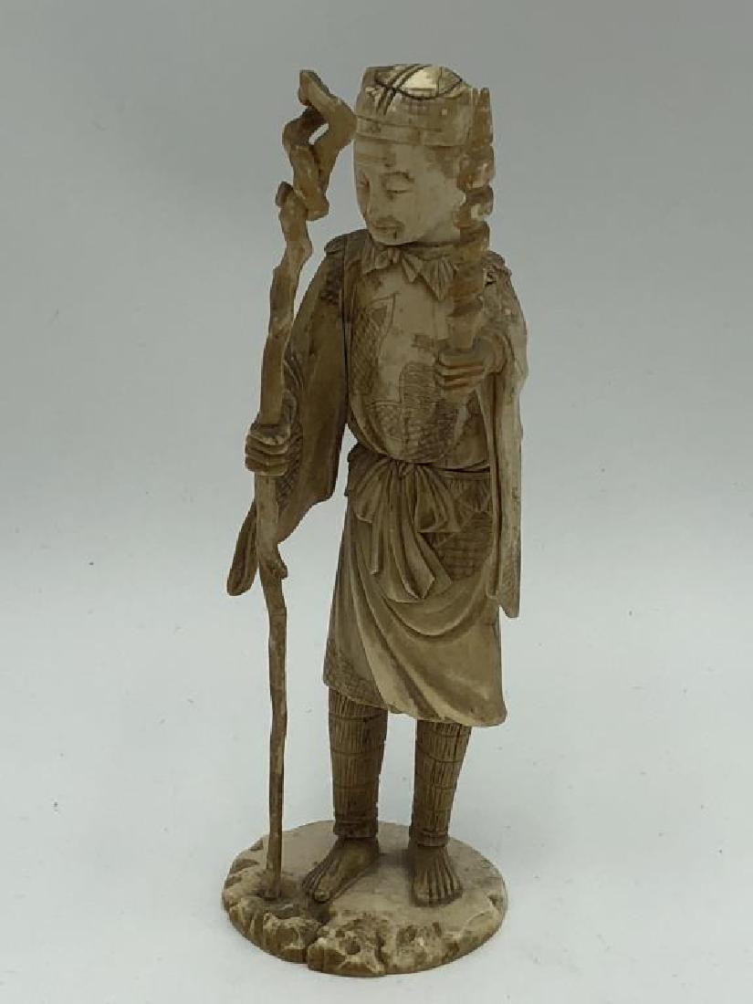 Antique Bone Carving: Detailed carving of Elder with spiral sword and scepter. Heigh is 7 inches, 2.5 inch diameter base with markings on bottom.