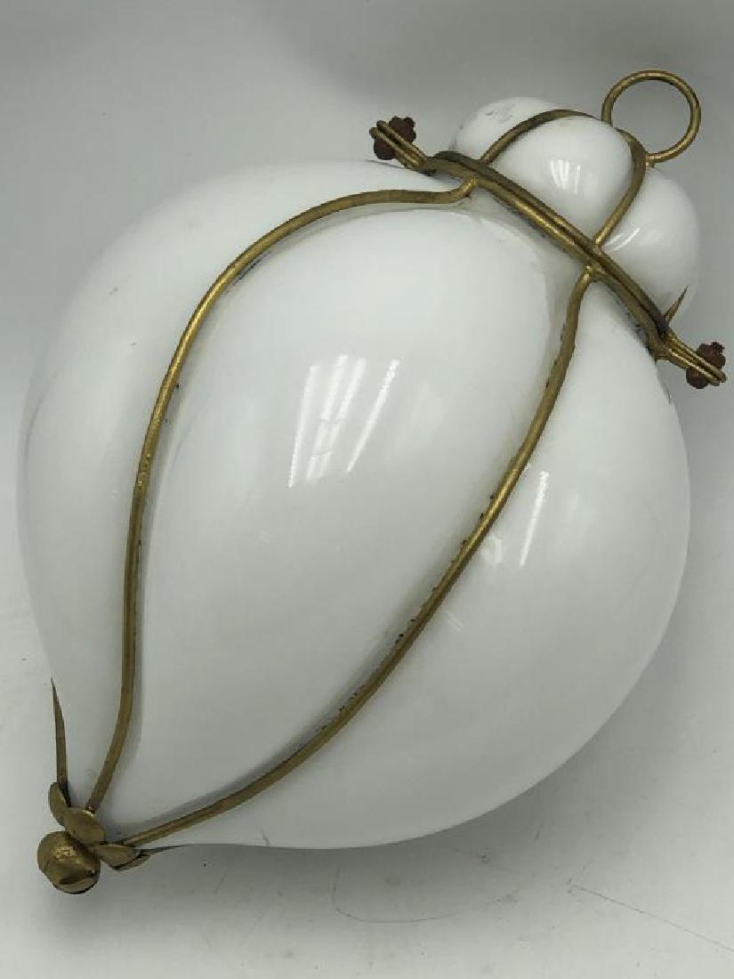 Milk Glass Pendant with Metal Frame: White glass pendant that has been blown through the decorative wire frame. The bowl and lid are secured together, metal frame is painted gold with decorative flower at bottom. Some rust and wear on gl