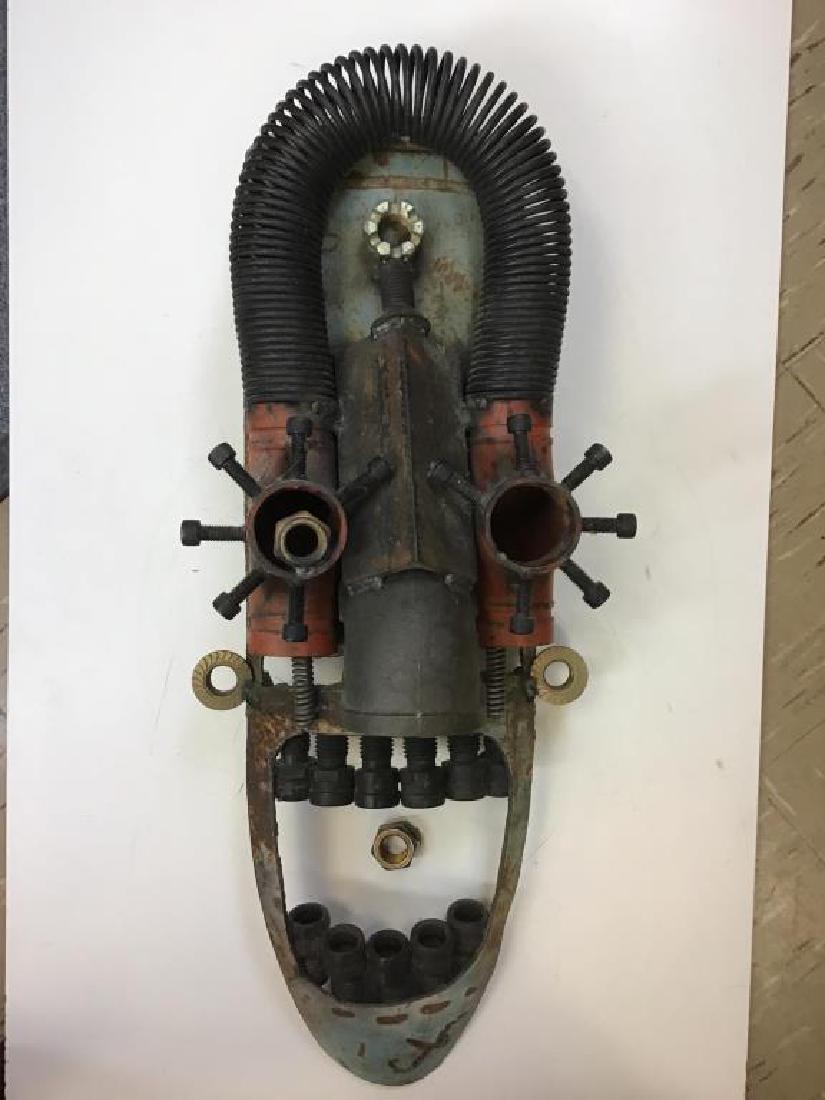 Repurposed Metal Mask by Conlon: Wall hanging mask sculpture made from repurposed metal and industrial hardware. Metal nut of right eye needs to be secured. Signature welded into chin "Conlon" by the artist, Fred Conlon, of Salt Lake