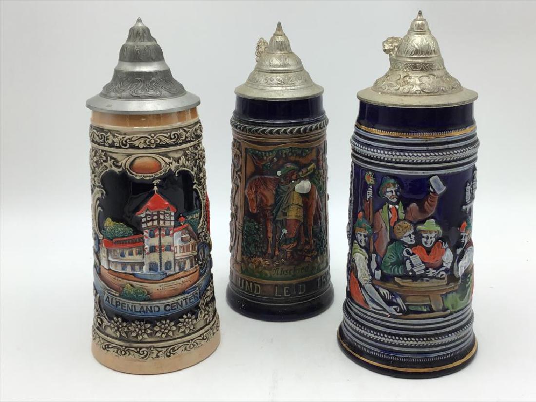 Three German Steins: Lot of three German steins, different markings on bottom, featuring one GERZ, largest is about 11 inches high with 4 1/2 inch diameter.