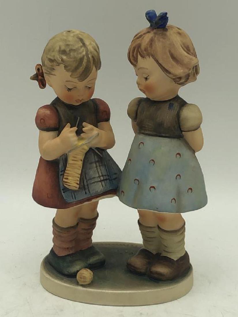 Girls sewing Hummel Figure: Hummel figure of two young girls sewing. MJ Hummel signature on base, maker mark on bottom in blue, numbered 256, 22, good condition. Measures about 7.5 inches high by 4 inches wide by 3 inches deep.