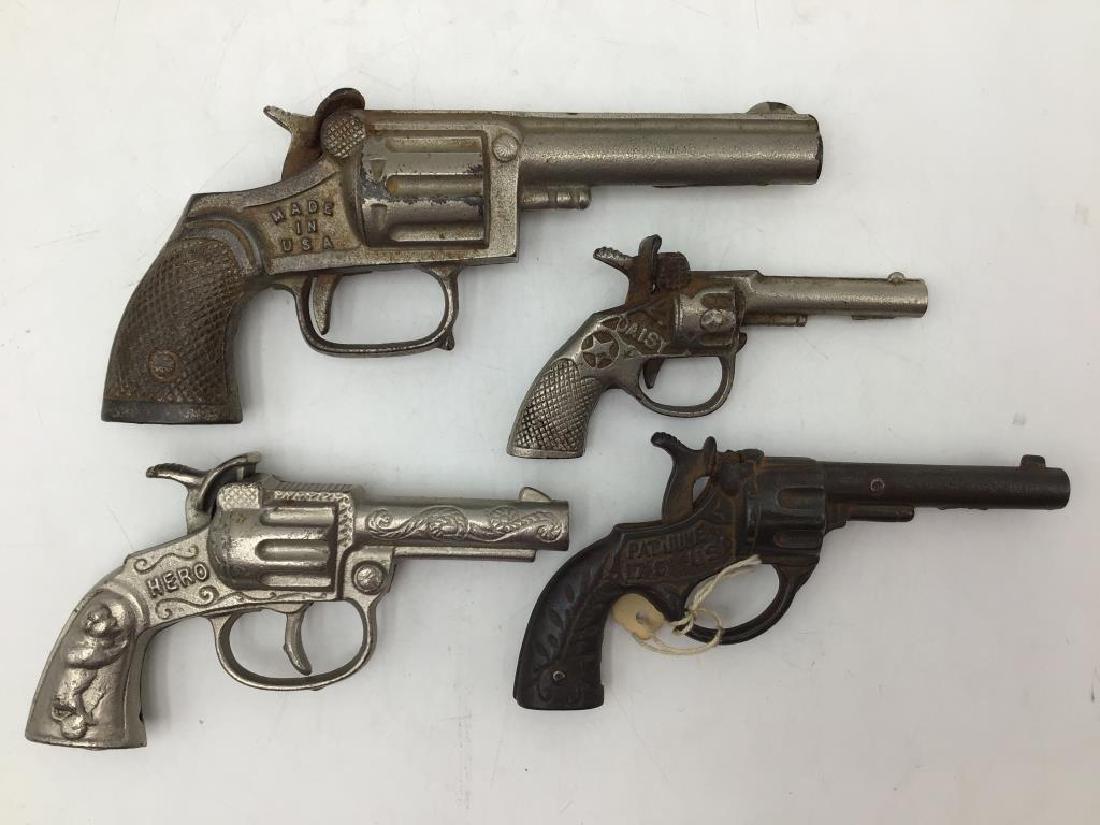 4 cast iron cap guns: Models are daisy, model pat June 17 1891 usa, hero and scout. Scout is the largest at 7 inches. All work. Provenance: From the Estate of Raymond Bentley.