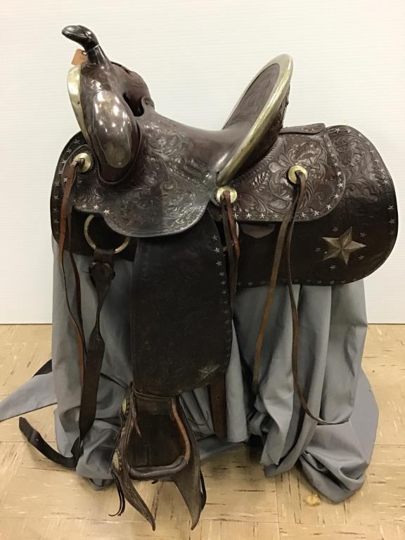 Western Leather and ornate silver saddle: heavily tooled leather saddle, Stamped with “Blake Miller Cheyenne, Wyo" monogram engraved on back silver plate. ornate silver engraving, heavily tooled leather, Measures 18 1/2 inches from back of 