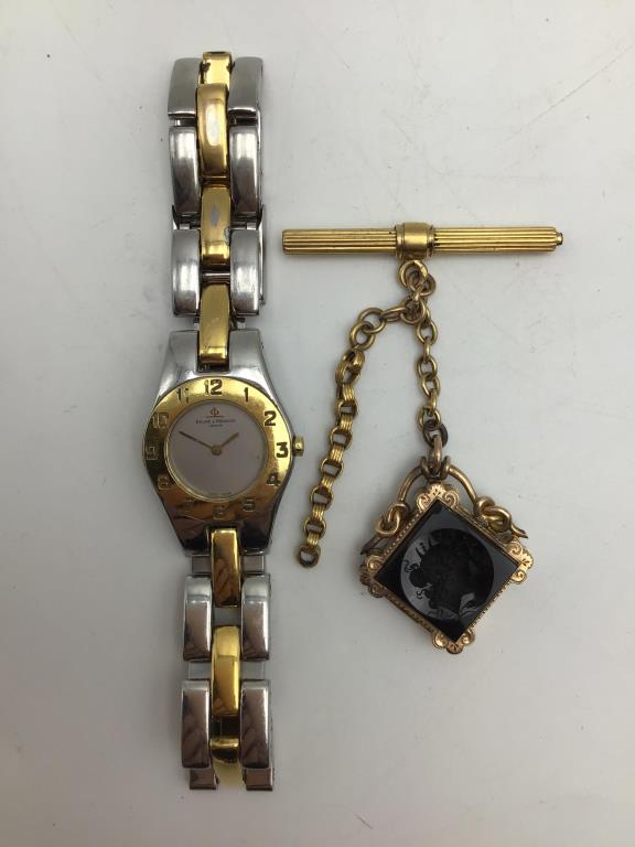 Ladies Locket and Watch Lot: Two items in Lot, includes a French Gold watch chain fob with open locket for photos, and a gold plated and stainless steel ladies watch by Baume and Mercier, light scratched on watch surface. Gold ch