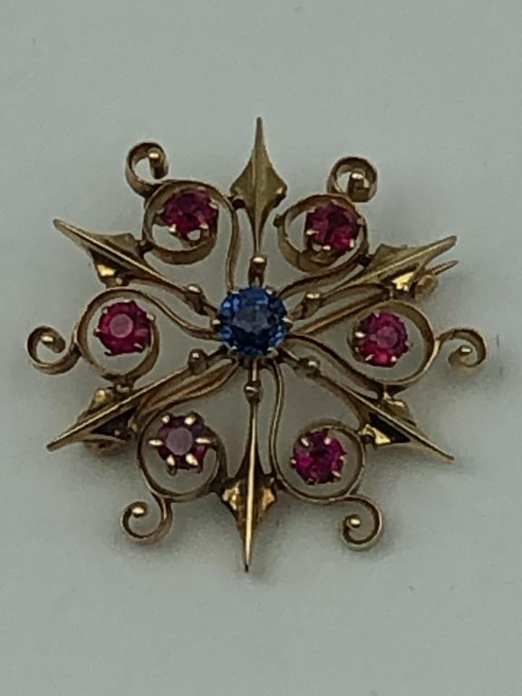 14K Blue and Red Stoned Pin: 6 - 3.25mm red stones, 1 - 4.5mm blue stone, 1-1/8" in diameter. 3.75 dwt.