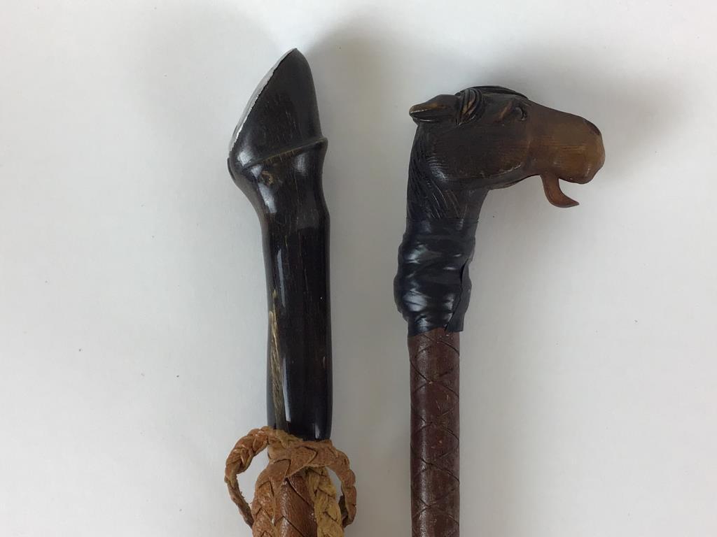 Two antique horse crops: Including carved Horn hoof shaped handle with braided leather-24 inches, carved wooden horse head handle – mechanical mouth, taped onto braided leather crop-24 inches