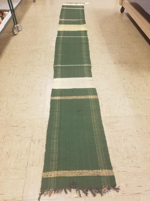 14 ft long Rag Rug: Colorful green main color with touches of yellow, blue, cream and orange. Same pattern on both sides. Measures 14 foot long x 20 inches wide.
