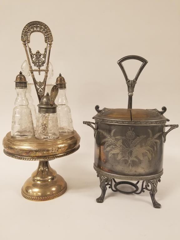Two cruet holders, one has a cruet set: Rogers and Bro silverplate rotating cruet holder with etched glass 5 pc cruet set, 17 inches tall. Unmarked silverplate covered cruet holder is 14 inches tall.
