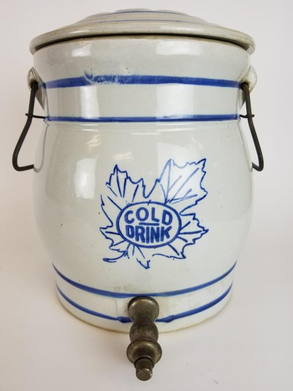Stoneware beverage cooler: 2 gallon Stoneware crock with push button spigot for serving beverages. With metal handles and cover. Measures 12 inches tall. Made in Monmouth IL.