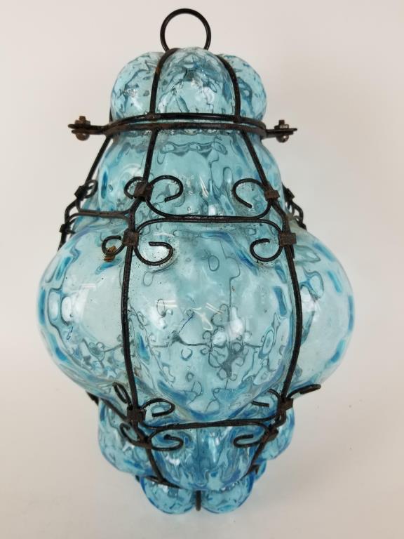 Hand blown caged glass pendant light shade: Blue hand blown glass, blown inside a metal frame. Top opens to install a light fixture if desired. Measures 13 inches tall
