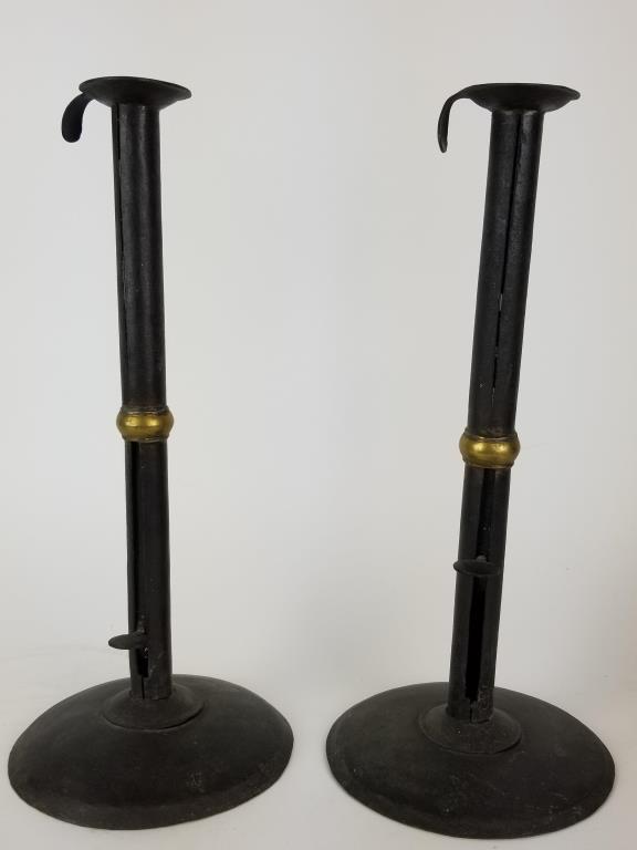 Pair of Wedding Band Hogscraper candlesticks: Push up candleholders made of sheet iron with decorative center brass rings. Thumb ejector tabs appear to be unsigned. The Bobeche have hook extensions for hanging. Each measures 12.5 inches tall.