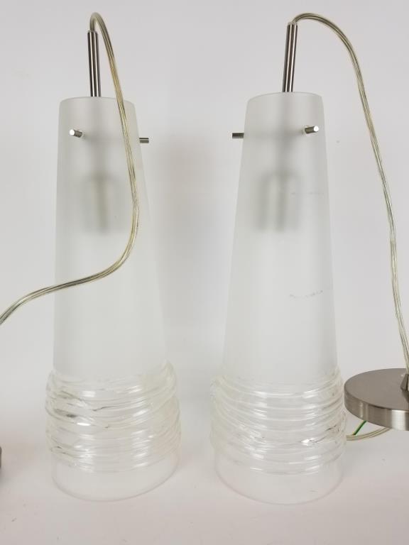 2 Mid Century Oggetti Luce glass pendant lights: Frosted glass shades each measure 14 inches tall. Come with wiring and mounting bezel. One shade has some trim damage.