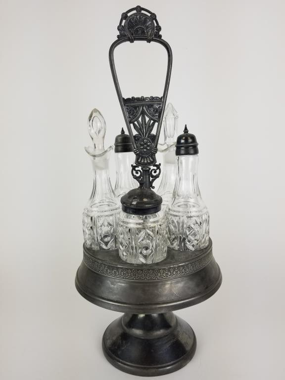 Silver plated cruet set and rack: Pairpoint Mfg Co. quadruple silver plated cruet rack, with glass and silver plate cruet set. Rack measures 16 inches tall. Front of base is engraved.
