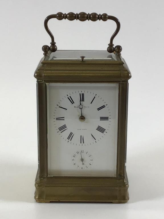 Hamann and Koch Grand Sonnerie Carriage clock: bronze ormolu case with white enamel dial having Roman numerals, hand missing, beveled glass sides and escapement window, 5.5 inches tall x 3.75 inches wide x 3.25 inches deep, not working