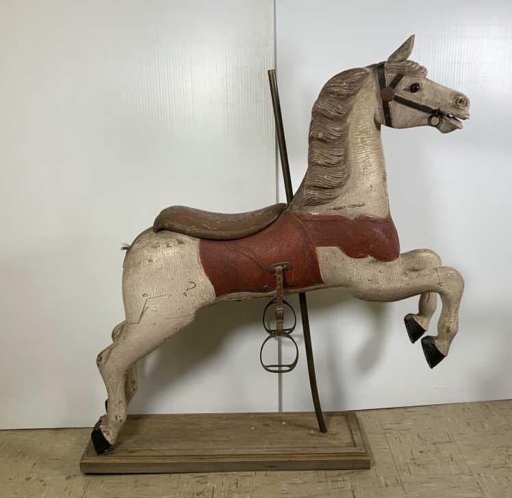 Antique carved wood carousel horse Hand painted Carved: Hand painted Carved Wood carousel horse, brown glass eyes, metal stirrups on leather straps, horse is 49 inches tall x 44 inches long x 11 inches wide, mounted on a pole and wooden platform