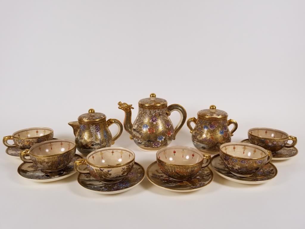 Japanese Satsuma tea set includes tea pot, cream,: includes tea pot, cream, sugar, six cups, six saucers, teapot has applied dragon head spout, ornately decorated with flowers and birds, applied handle on sugar and cream are also dragon heads.