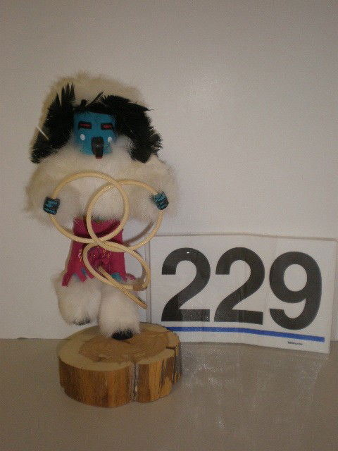 Kachana Navajo style wooden doll. 1988, decorated: Kachana Navajo style wooden doll. 1988, decorated with bright paint colors, bright fabrics, white fur and black feathers, 12 1/2" H.