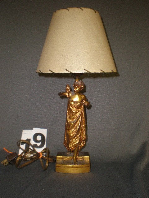 "The Secret" Nude figural lamp. Gilt pot metal fema: "The Secret" Nude figural lamp. Gilt pot metal female nude with hinged wrap, robe opens to reveal her secret, walking dow carpeted steps, holding torch, lamp extending from back, figure 9.5"H.