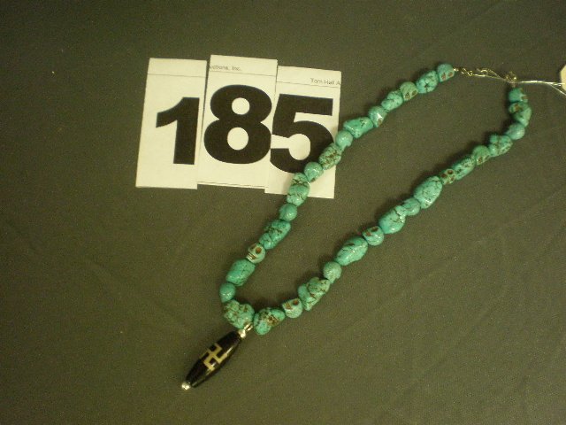 Turquoise Necklace: 20" carved turquoise skull necklace with Chinese WAN symbol pendant.