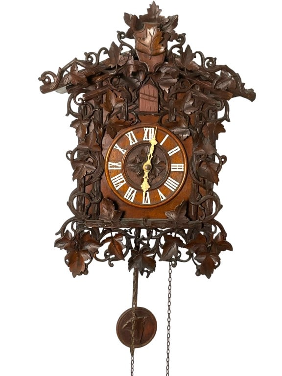 Ami Rivenc Black Forest Cuckoo Clock: Beautifully carved dark wood Leaf exterior with carved bone like hands. Bird has a nick on his beak. Weights, pendulum and chains present. Marked Ami Rivenc Fabricant Geneve. Internals are loose but h
